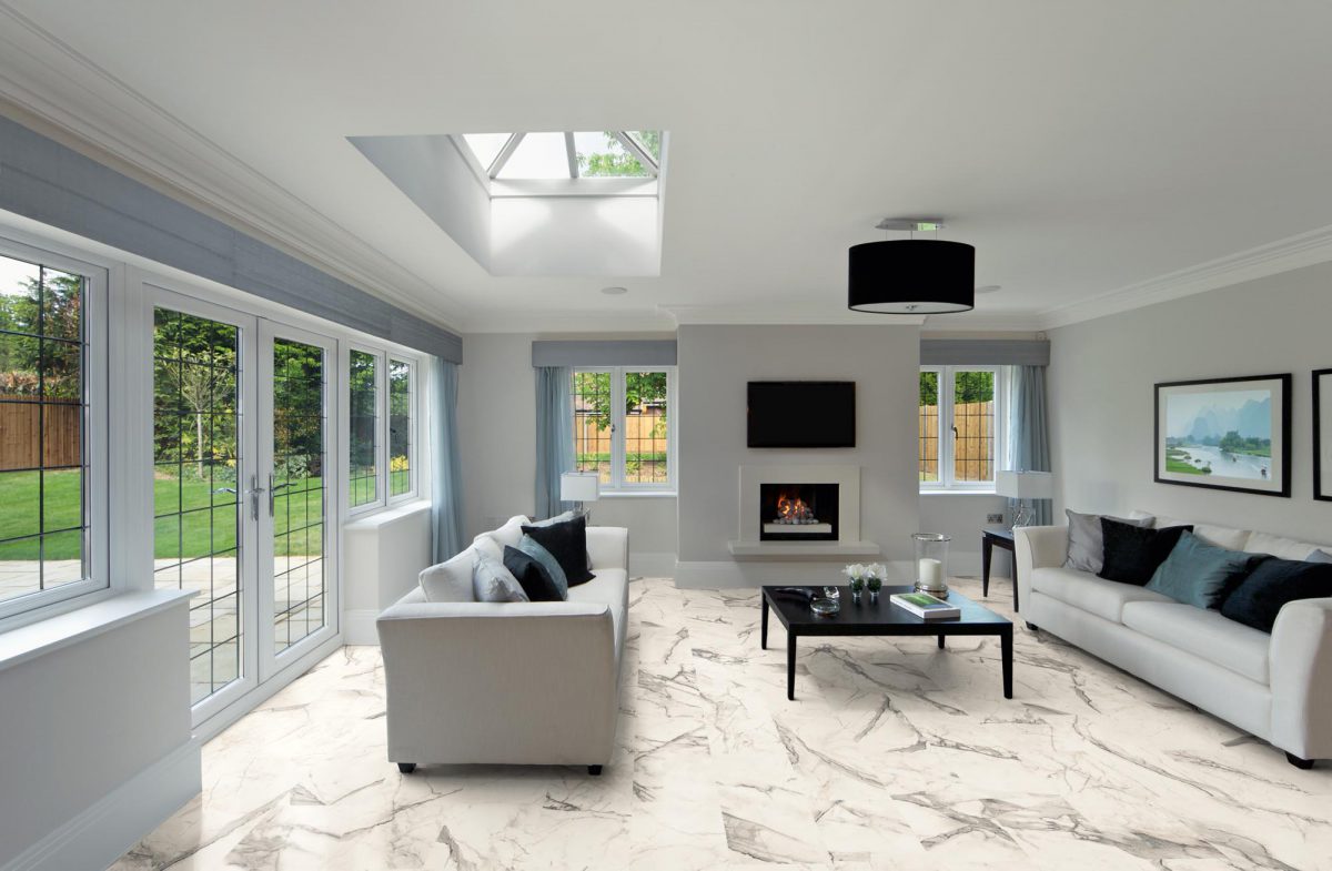 a beautiful, spacious and bright sitting room in an expensive new home. Two settees with silk cushions are set either side of a coffee table. A modern fire place is alight whilst light is streaming into the room via the roof light and leaded glass patio doors. All artwork (book and picture on the wall) are from my own images in the iStock library.