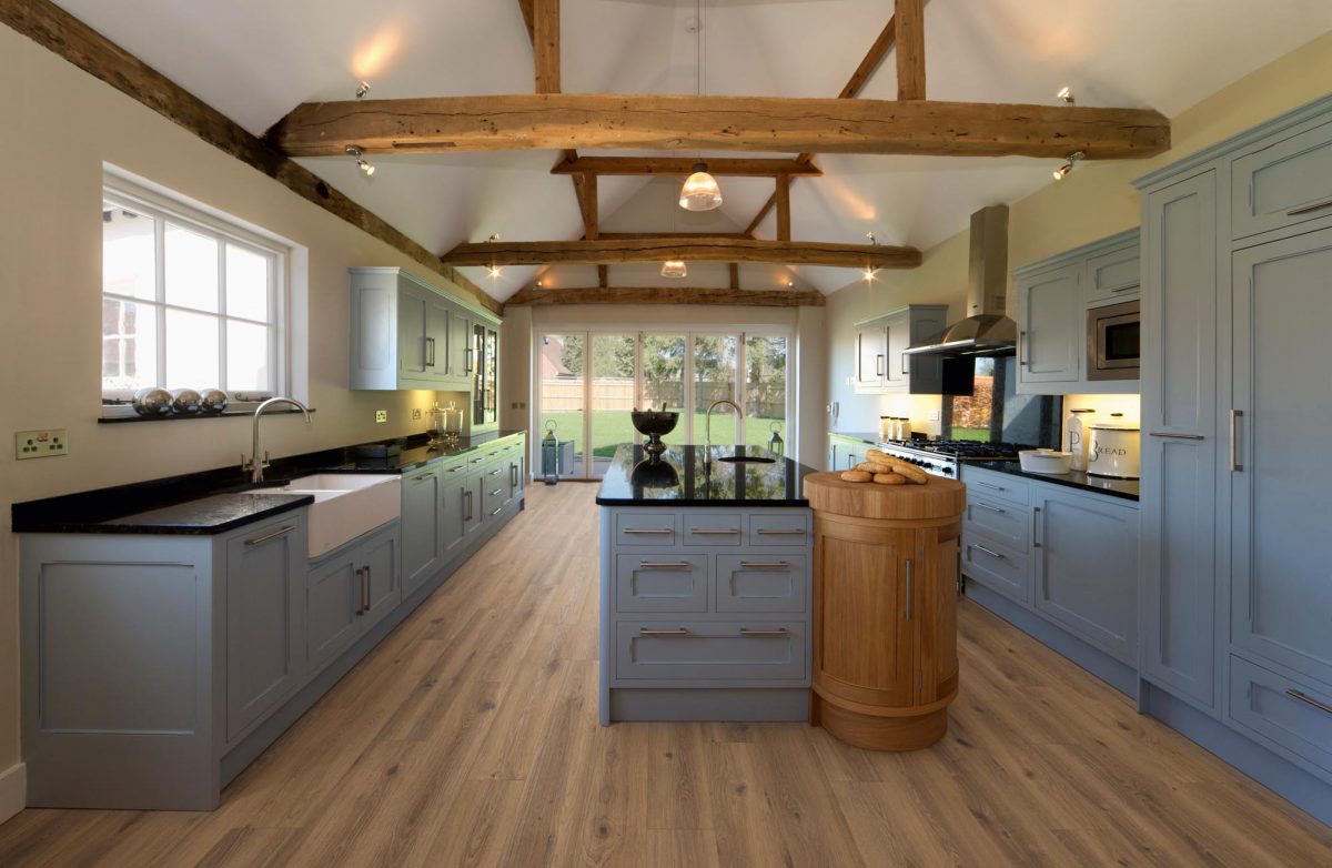 a beautiful farmhouse kitchen in a fully restored and rebuilt farm. Old, weathered oak beams support the roof and ceiling. Brand new terracotta flooring compliments the pastel toned powder blue cupboards and large kitchen island. This is a modern featured kitchen with all the appliances but constructed in a traditional style and being faithful to the 500 year old building.