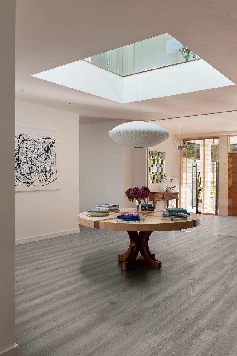 Spacious entrance hall with wood flooring, circular sycamore table by Nick Bourne and Bubble Saucer pendant light by George Nelson for Modernica